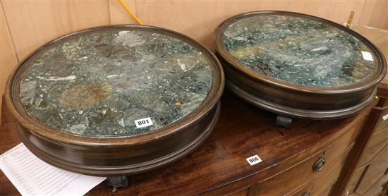 A pair of circular wood green marble inset framed pedestal stands, on castors, W.51cm